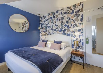 Chambre double de l'Hôtel Les Chants d'Ailes à La Turballe, avec lit en bois et lumière naturelle